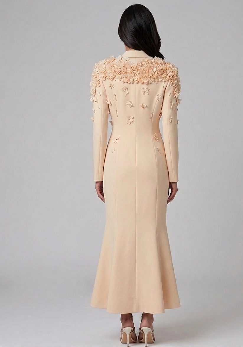 Beige dress with floral embellishments on a gray background