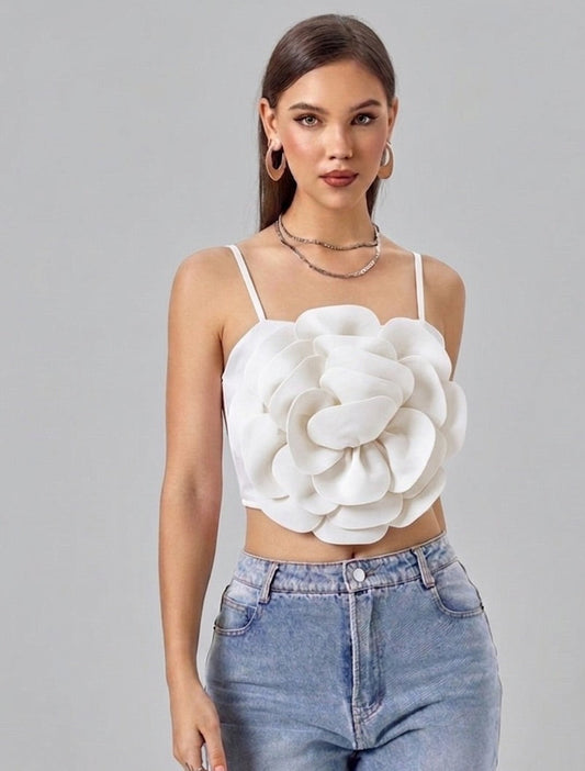 Woman wearing a white floral top and blue jeans on a gray background