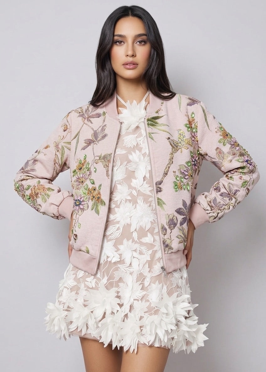 Woman wearing a floral jacket over a lace dress on a gray background