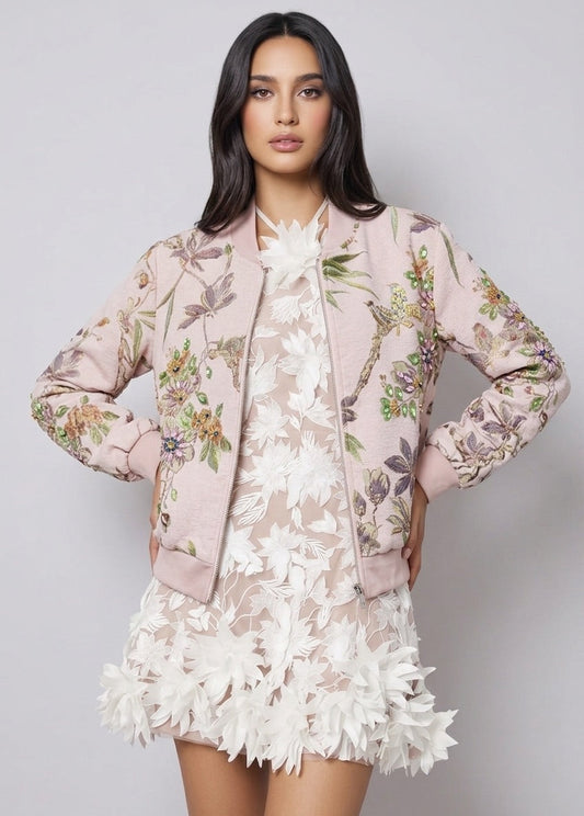 Woman wearing a floral jacket over a lace dress on a gray background