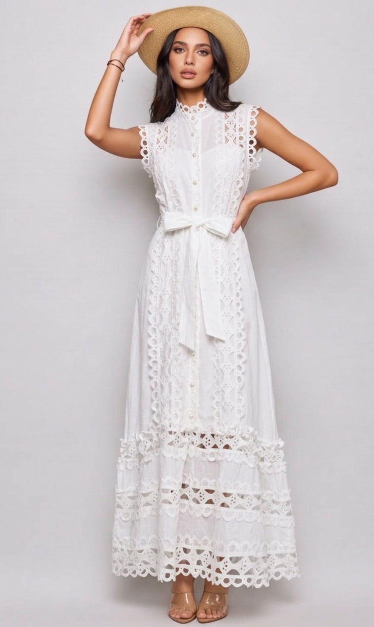 Woman wearing a white lace dress and straw hat on a plain background